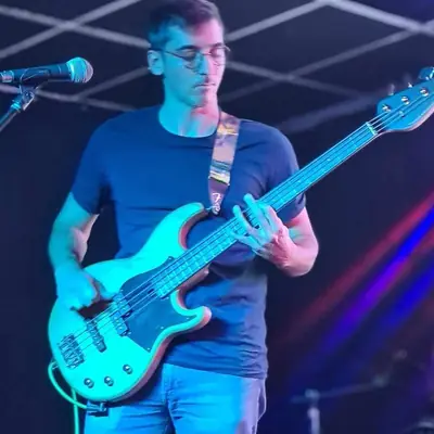 Quentin à la basse sur scène, de profil, pendant un concert